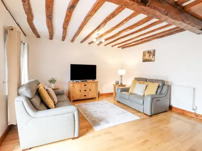 a living room with two chairs and a flat screen tv at Isallt in Llanbedr
