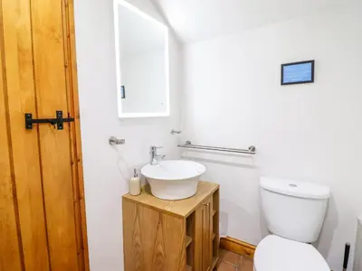 a bathroom with a toilet and a sink at Cwm Yr Afon Cottage in Harlech