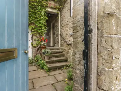 an entrance to a house with a blue door and stairs at The School Room in Kington