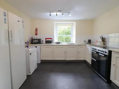 a kitchen with white appliances and a window at Bryn Cemlyn in Llanfachreth