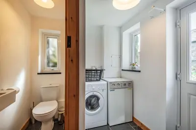 a bathroom with a washing machine and a toilet at Ty Capel Jeriwsalem in Trawsfynydd
