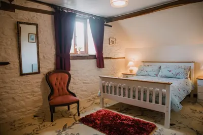 a bedroom with a bed and a chair and a mirror at Stargazer's Loft in Clifford