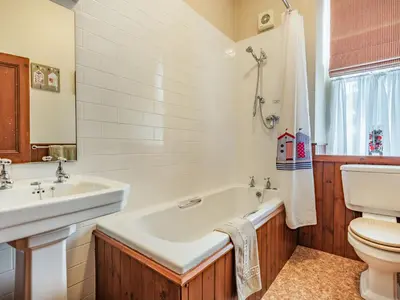 a bathroom with a tub and a sink and a toilet at Pensarn Hall in Llanbedr
