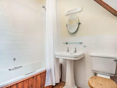 a bathroom with a sink and a toilet and a tub at Pensarn Hall in Llanbedr