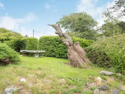 a tree stump in the grass next to a bench at Pensarn Hall in Llanbedr