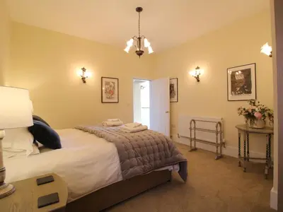 a bedroom with a bed and a table with flowers at The Maltster's House in Ludlow