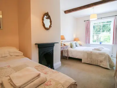 a bedroom with two beds and a fireplace at The Maltster's House in Ludlow