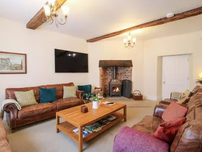 a living room with leather furniture and a fireplace at The Maltster's House in Ludlow