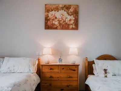 a bedroom with two beds and a painting on the wall at Stargazer's Field House in Clifford