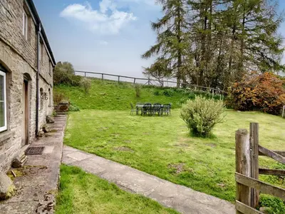 a garden with tables and chairs on a hill at The Birches in Craswall