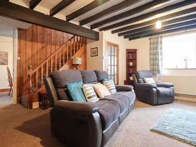 a living room with a couch and two chairs at Bryn Re in Trawsfynydd