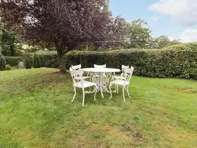 a white table and chairs in the grass at Beacons Rest in Llanspyddid