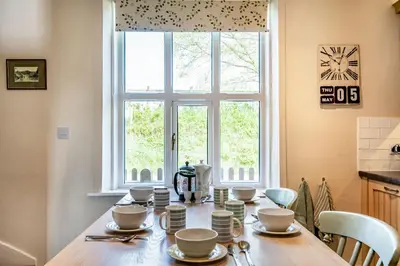 a kitchen with a table with cups and dishes on it at 2 Siluria Cottage in New Radnor