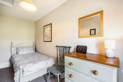 a bedroom with a bed and a dresser with a mirror at 2 Siluria Cottage in New Radnor
