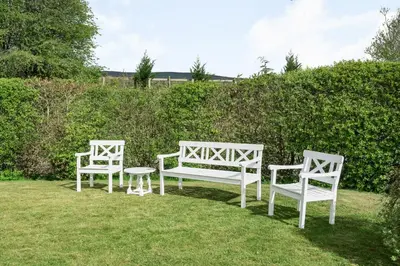 three white chairs and a table in the grass at 2 Siluria Cottage in New Radnor