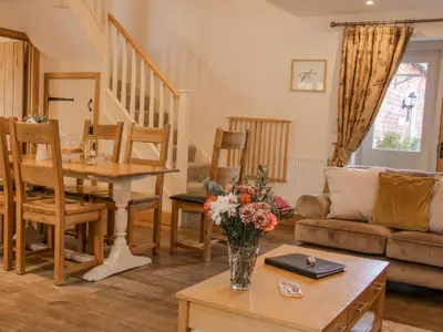 a living room with a vase of flowers on a table at The Turnip House in Acton Scott