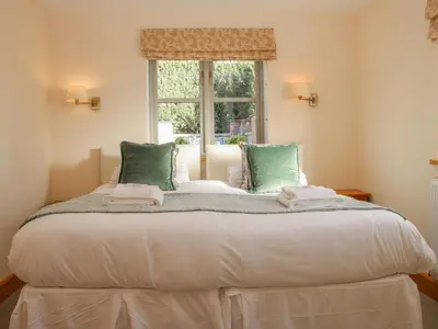 a large bed in a room with a window at The Turnip House in Acton Scott