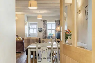 a dining room and living room with a table and chairs at 2 Bryn Tirion in Tanygrisiau
