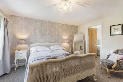 a bedroom with a large bed and a chair at 2 Bryn Tirion in Tanygrisiau