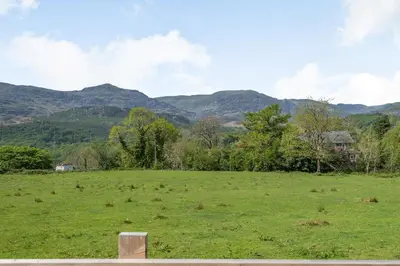 a field of grass with mountains in the background at Gorwel in Blaenau-Ffestiniog