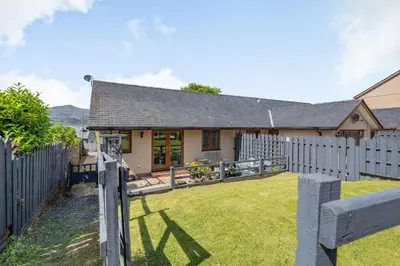 a house with a fence and a yard at Gorwel in Blaenau-Ffestiniog