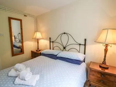 a bedroom with a bed with towels on it at Salmon Cottage in Llanwrthwl