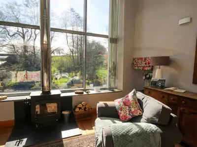 a living room with a fireplace and a couch at The Barn at Glanoer in Bettws Disserth