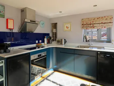 a kitchen with blue and white counters and appliances at The Barn at Glanoer in Bettws Disserth
