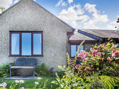 a blue bench sitting in the yard of a house at Llety Nest in Llanfachreth