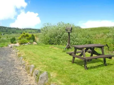 a picnic table and a light on a field at Stabal Cottage in Cross Foxes