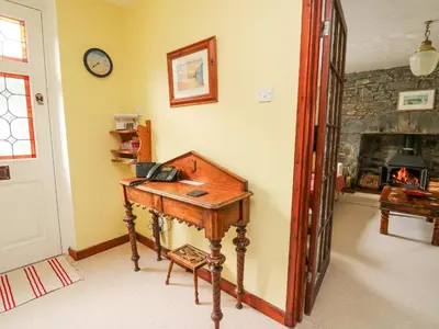 a wooden desk in a room with a fireplace at Derwen Villa in Mydroilin