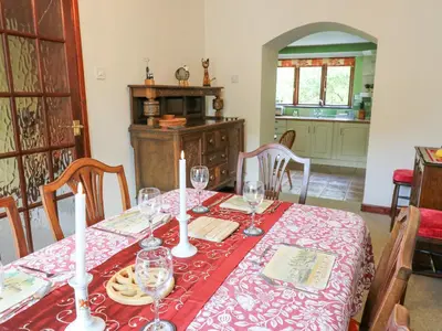 a dining room table with a red table cloth at Derwen Villa in Mydroilin