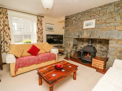 a living room with a couch and a fireplace at Derwen Villa in Mydroilin