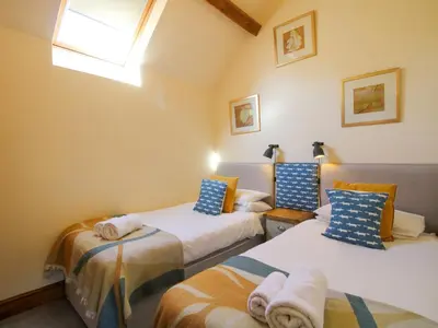 a bedroom with two beds and a window at Trooper's Barn in Acton Scott