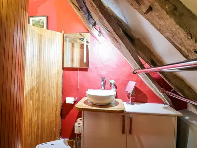 a bathroom with a sink and a red wall at St Mary's in Tal-y-llyn