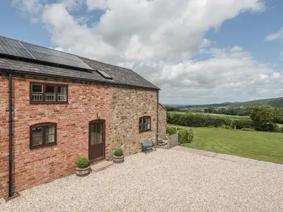 an external view of a brick house with a patio at Hope Hall Barn in Bromlow