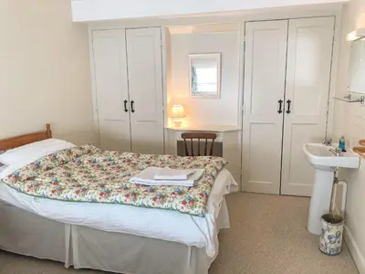 a bedroom with a bed and a sink in it at Hope Hall Barn in Bromlow
