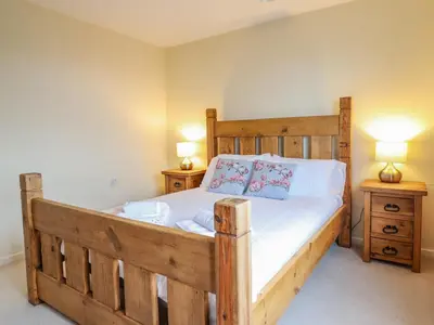 a bedroom with a wooden bed with two night stands at The Villa in Harlech