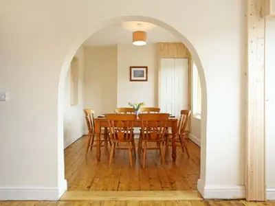 a dining room with a wooden table and chairs at Trysor Y Mor in Borth