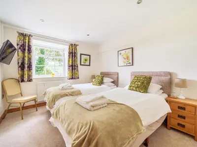 a bedroom with two beds and a window at Old Rectory Cottages in Aberhafesp