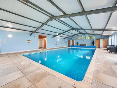 a swimming pool in a building with a ceiling at Old Rectory Cottages in Aberhafesp