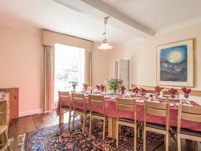 a dining room with a long table and chairs at The Old Schoolhouse and Cottage in Bishops Castle