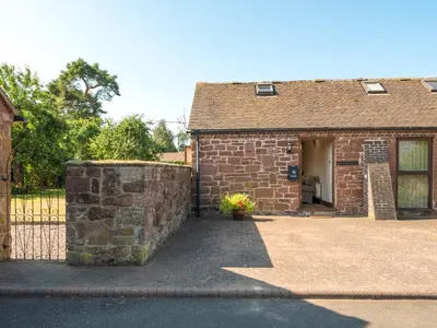 a brick house with a gate and a stone wall at Parrs Meadow Cottage in Pitchford