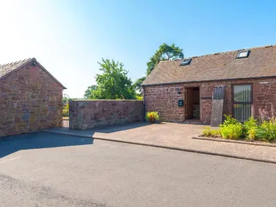 a brick house with a driveway in front of it at Parrs Meadow Cottage in Pitchford