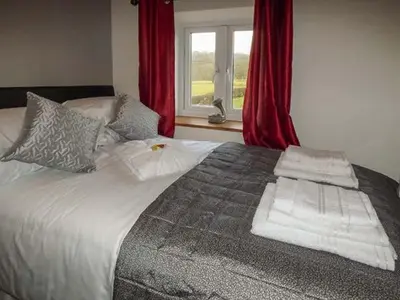 a bed with towels on it in a room with a window at Cwmcelyn in Nantmel