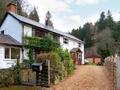 a white house with a fence in front of it at Forestry Cottage in Pale