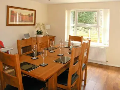 a dining room with a wooden table with wine glasses at Forestry Cottage in Pale