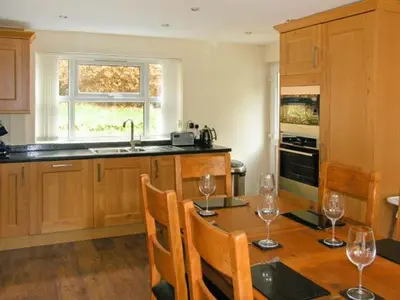 a kitchen with a wooden table with wine glasses on it at Forestry Cottage in Pale