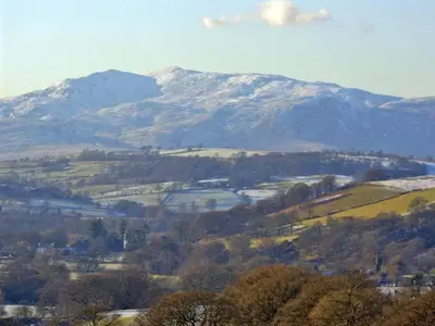 a snow covered mountain in a valley with trees at Forestry Cottage in Pale