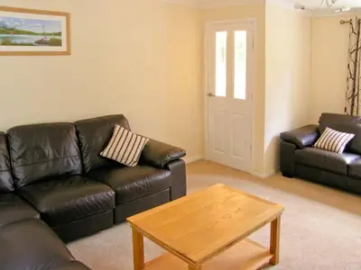 a living room with a leather couch and a coffee table at Forestry Cottage in Pale